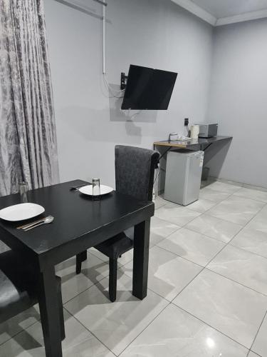 a dining room with a black table and a television at Bethlehem Guest House in Bethlehem
