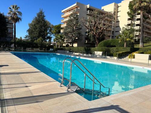 une piscine avec des escaliers dans un immeuble d'appartements dans l'établissement 2 pièces centre Juan moderne avec piscine tennis, à Antibes