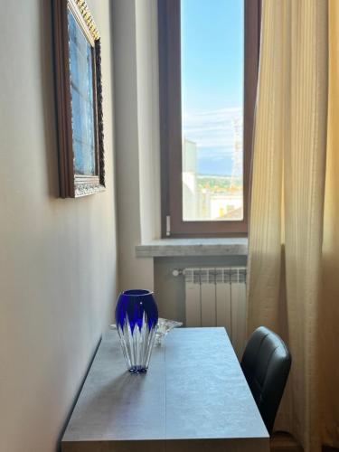 a blue glass vase sitting on a table with a window at Cavour Luxury Rooms Catanzaro in Catanzaro