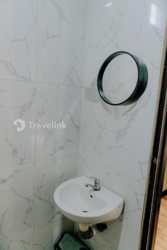 a bathroom with a sink and a mirror on the wall at Vianda Cabin By Travelink in Kejajar
