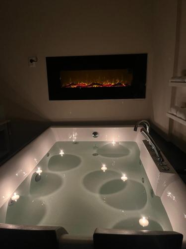 a bath tub with candles in front of a fireplace at La Corte dei Prefetti di Vico Bellavista Relax in Ronciglione