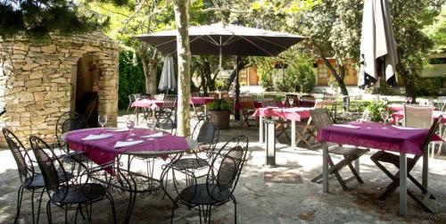 a group of purple tables and chairs with an umbrella at Hotel Sara De Ur in La Cabrera