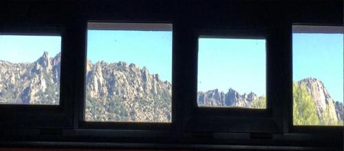 a view of a mountain range from a window at Hotel Sara De Ur in La Cabrera