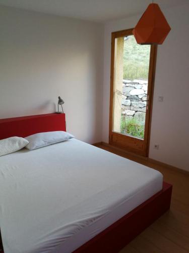 une chambre avec un grand lit avec une fenêtre dans l'établissement cottage with view of La Grave La Meije, à La Grave