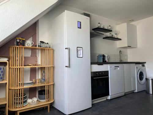 La cuisine est équipée d'un réfrigérateur blanc et d'un lave-vaisselle. dans l'établissement Appartement à la montagne 10 chambres 5 douches and 4 WC, à Argelès-Gazost