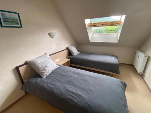 une petite chambre avec deux lits et une fenêtre dans l'établissement Appartement à la montagne 10 chambres 5 douches and 4 WC, à Argelès-Gazost