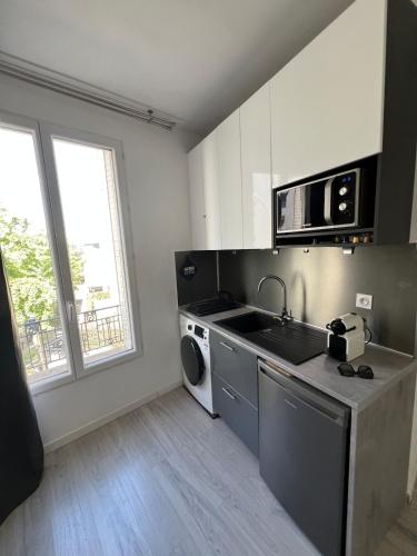 une cuisine avec un évier et une machine à laver dans l'établissement Appartement 2p near Paris, au Kremlin-Bicêtre