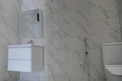 a bathroom with white marble walls and a mirror at chez Aissam in Tangier