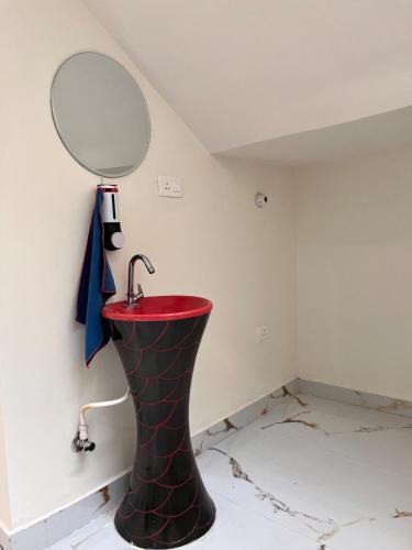 a bathroom with a red sink and a mirror at Sukoon Guaranteed in Jhājra