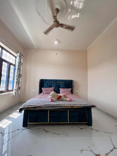 a bedroom with a teddy bear laying on a bed at Sukoon Guaranteed in Jhājra