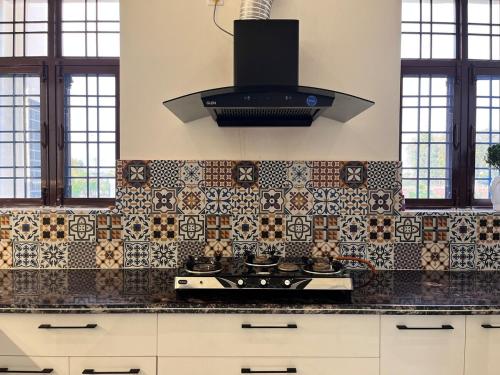 a kitchen with a stove and a hood at Sukoon Guaranteed in Jhājra