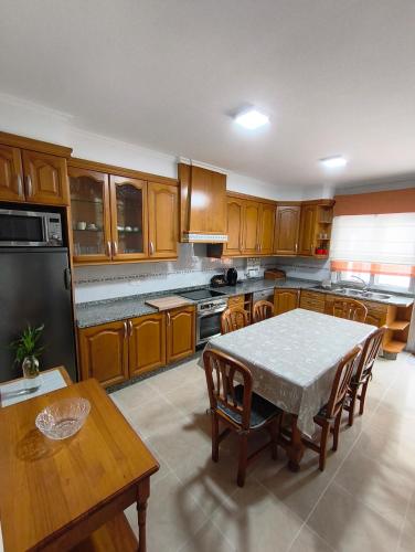 a kitchen with wooden cabinets and a table with chairs at Casa O Con in O Grove