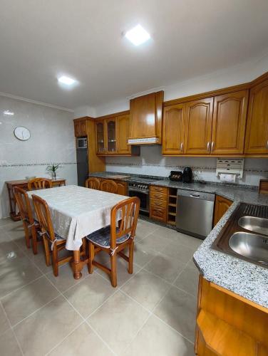 a kitchen with a table and chairs and a sink at Casa O Con in O Grove