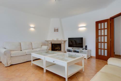 a living room with a white couch and a fireplace at Spacious Villa - Walk to Beach & City Center in Lagos