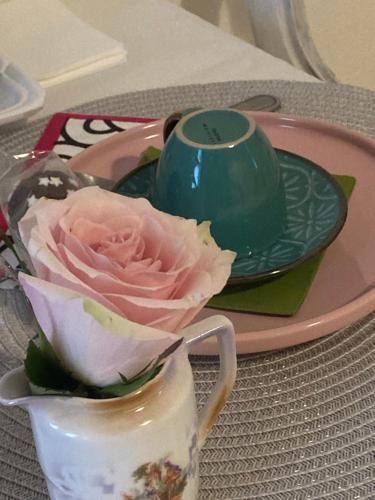 a flower in a vase on a table with a plate at Antica Novi B & B in Novi Ligure