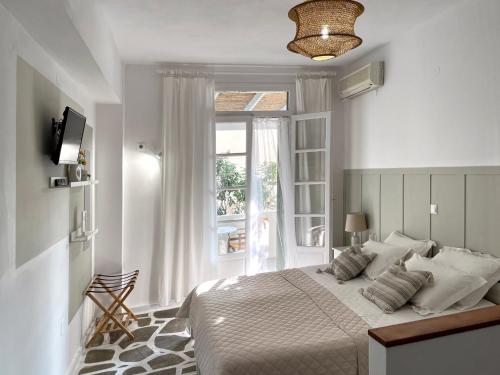 a white bedroom with a bed and a window at Georgios Milos in Adamas
