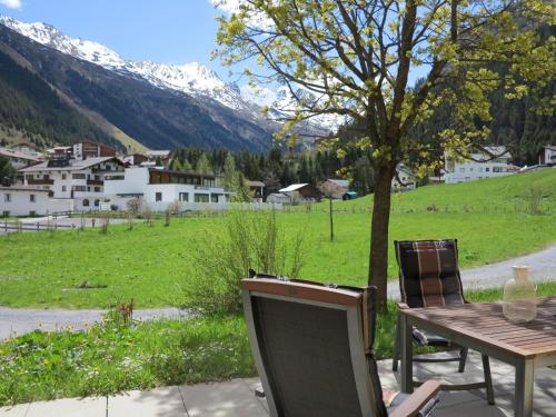 a table and chairs on a patio with a view of a mountain at 4two in Galtür