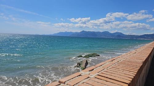 a brick pathway leading to the ocean with mountains at B&B SOLE e LUNA in Pontecagnano