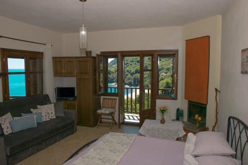 a living room with a couch and a table at The Bird's Sea View in Agios Ioannis Pelio