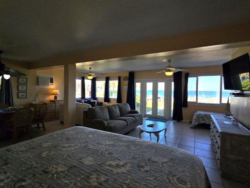 a bedroom with a bed and a living room with a couch at Oceanfront Sea Scape Motel in Melbourne
