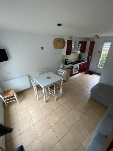 une cuisine et un salon avec une table et des chaises dans l'établissement Maison à 100m de la mer, à Piriac-sur-Mer