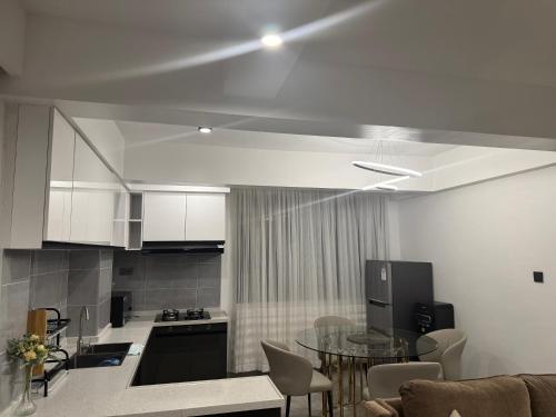 a living room with a table and a kitchen at City oasis garden in Nairobi