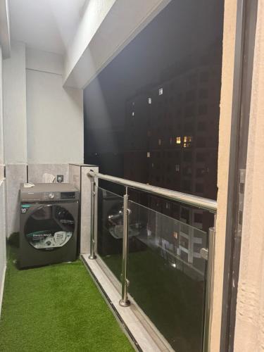 a balcony with green grass and a washing machine at City oasis garden in Nairobi