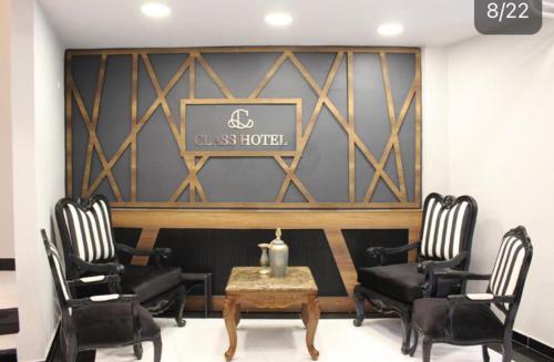 a room with chairs and a table and a sign at Class Hotel in Kırklareli