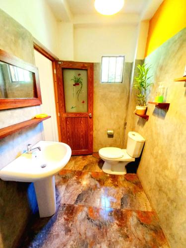 a bathroom with a toilet and a sink at Coco Garden Villas 3 in Hikkaduwa