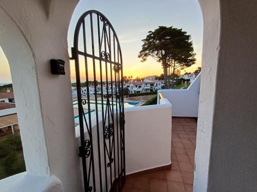 a gate to a balcony with a view of a pool at Casa NURA in Son Bou