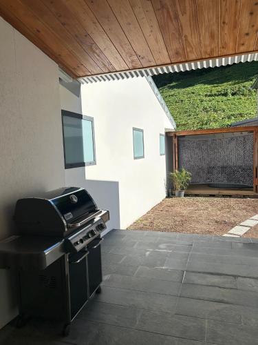 a barbecue grill in a backyard with a patio at Villa Soalazy T4 Confort&Nature in Salazie
