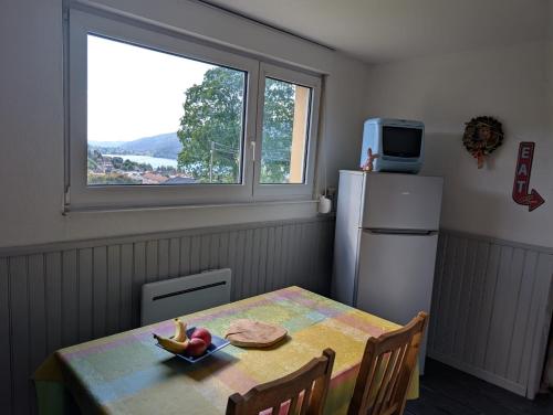 Il comprend une cuisine équipée d'une table et d'un réfrigérateur. dans l'établissement Entre lac et pistes, à Gérardmer