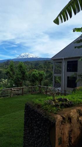 a snow covered mountain in the distance behind a house at Materuni Homes in Moshi