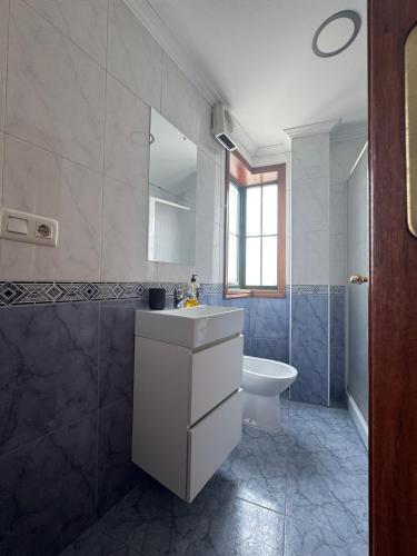 a bathroom with a sink and a toilet and a mirror at PISO MOAÑA in Moaña