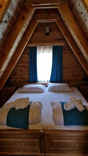 a bed in the attic with two people laying on it at Princess Jana Apartments in Selišta