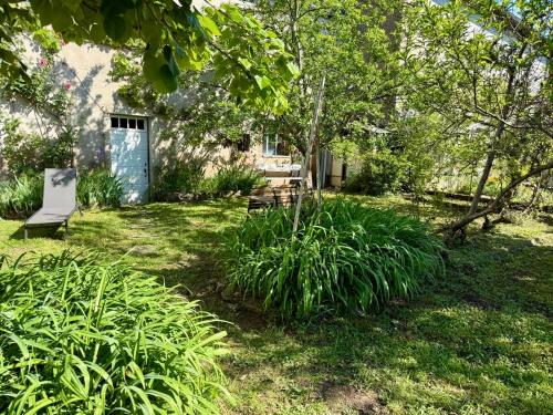 a yard with a bench and some plants at La maison de Jean-Pierre  in Devecey