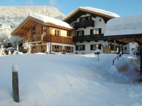 a snow covered building with a snow covered yard at Gästehaus Annemarie in Reit im Winkl