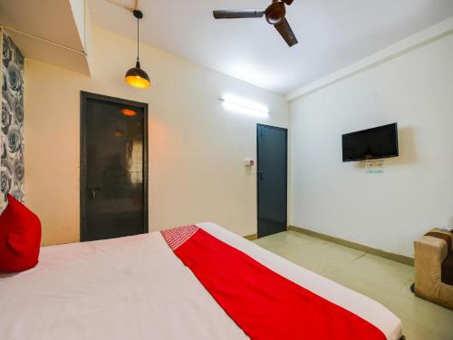 a bedroom with a red and white bed and a tv at Hotel O Unique Delhi Home Stay in New Delhi