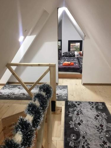 a attic room with a bed and a staircase at Villa Old Town Vlašić in Šišava