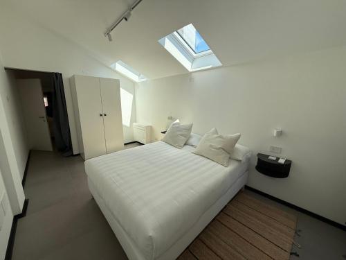 a bedroom with a large white bed with a window at Casa Anna in Venice