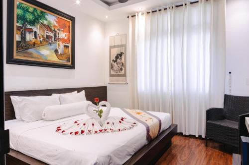 a bedroom with a bed with a swan decoration on it at Khách sạn Le Domaine De Cocodo in Hue