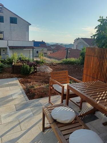a patio with a bench and a table and chairs at Lovelysuite Šibenik in Šibenik
