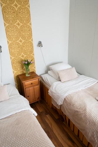 a room with two beds and a vase of flowers on a table at Hotel Homeland in Tampere