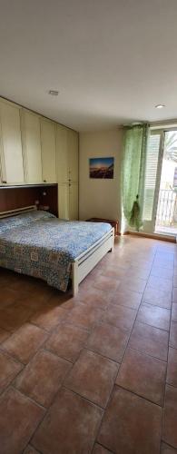 una camera da letto con un letto e un pavimento piastrellato di La casa di Piero a Fiumefreddo di Sicilia