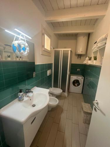 a bathroom with a white sink and a toilet at Isola Rossa House in Isola Rossa