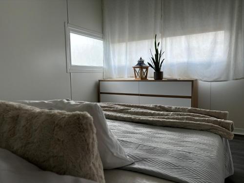 a bedroom with a bed with pillows and a window at rishko resort - Lake View - Private Sauna - free Parking - 24hr Self chceck-in in Holčíkovce