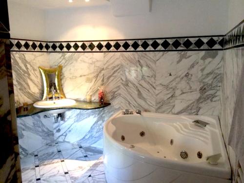 baño con bañera blanca y pared de mármol en Casa Bellavista en Sorrento