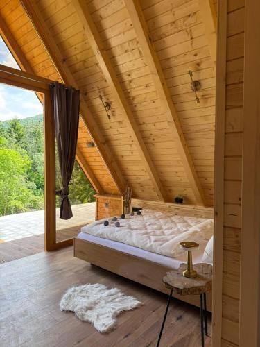 ein Schlafzimmer mit einem großen Bett in einer Holzdecke in der Unterkunft Cottage Lana 2 in Jajce