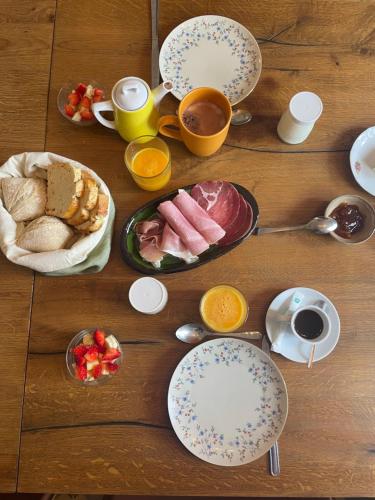 a table with plates of food and cups of coffee at Les volets verts in Saint-Laurent-de-la-Cabrerisse