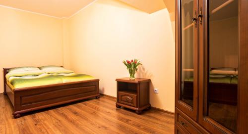 ダルウフコにあるCałoroczny apartament Darłówko Wschodnieのベッドルーム1室(ベッド1台、花のテーブル付)
